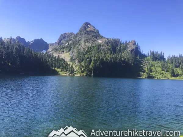 Backpacking Upper Lena Lake - Olympic National Park in Washington State. Upper Lena Lake is a gorgeous alpine lake located in Olympic National Park. This beautiful picturesque lake makes for an excellent summer backpacking destination for adventurous souls. The lake is crystal clear with vivid hues of blue and green. You can see every rock and even several large rainbow trout swimming. This strenuous 14-mile hike with 3,943 feet of elevation gain is not for the beginner hiker. But for those who wish to go on a journey and see some of Olympic National Park's untouched beauty, this is the backpacking destination for you.