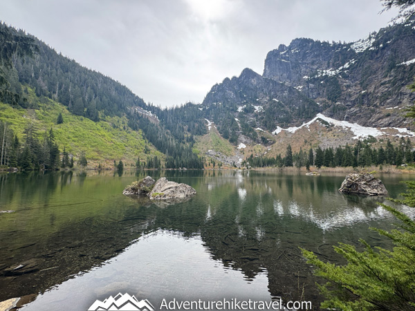Heather Lake offers one of Washington’s most rewarding alpine lake hikes with waterfalls, towering evergreens, and postcard-worthy mountain reflections at the lake.