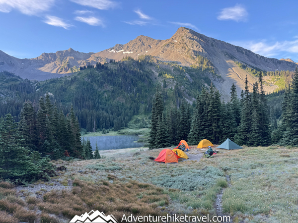 Scenic backpacking campsite at Moose Lake with views of the turquoise water, alpine meadows, and surrounding Olympic Mountains